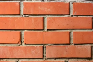 橙色砖墙，用不均匀的灰泥砌成。