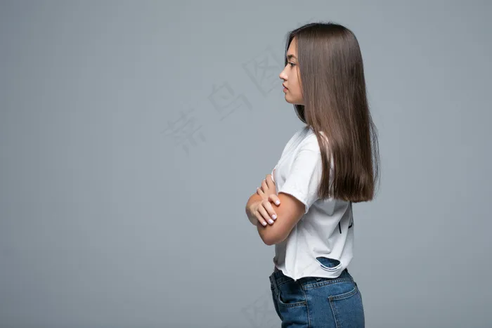 侧视图亚洲年轻女子室内摄影棚拍摄的肖像，孤立在浅灰色背景上。