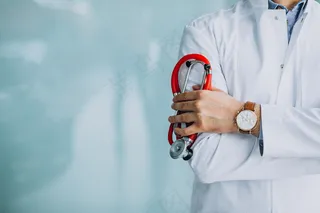 年轻英俊的内科医生，穿着带听诊器的医疗袍