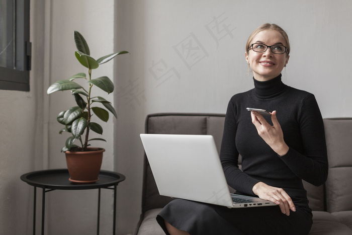 沙发上有手机和笔记本电脑的女人
