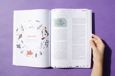 手拿着紫色背景的杂志