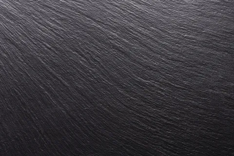 黑色石头，纹理为背景。平滑结构表面上的阴影和灯光