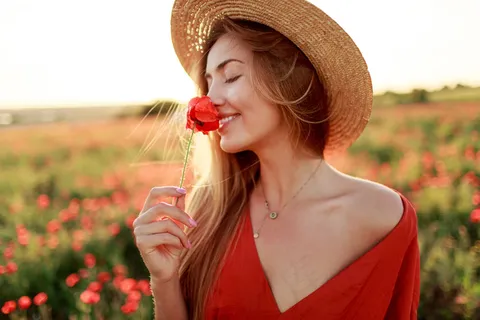 浪漫的金发女人手拿鲜花在神奇的罂粟地散步。暖暖的夕阳色。草帽。红色连衣裙。柔和的颜色。 浪漫的金发女人手拿鲜花在神奇的罂粟地散步。暖暖的夕阳色。草帽。红色连衣裙。柔和的颜色。