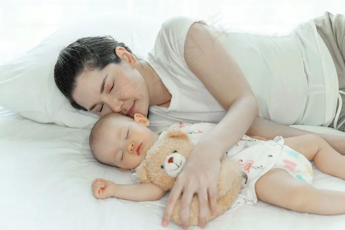 妈妈抱着孩子睡在卧室里
