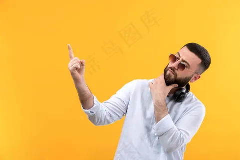 年轻人穿着白衬衫，留着胡子，戴着墨镜，戴着黑色耳机