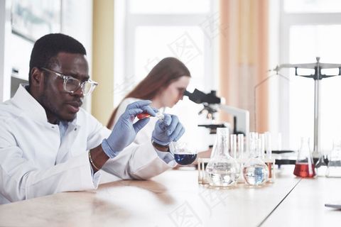 科学家在实验室里通过实验和分析与显微镜密切合作。 科学家在实验室里通过实验和分析与显微镜密切合作。