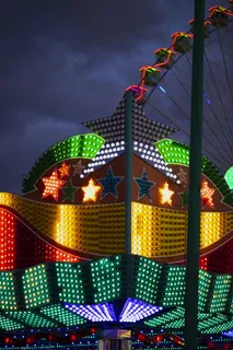 在摩天轮的背景上，五颜六色的星星形霓虹灯