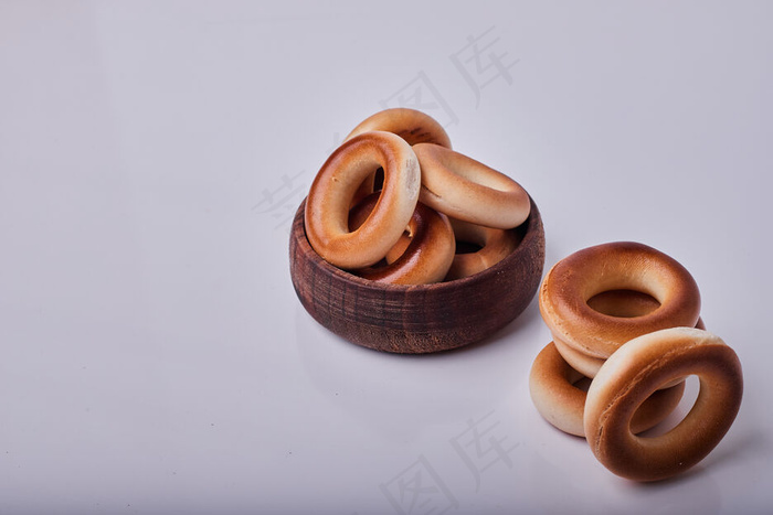 将饼干或糕点小圆面包放在灰色背景上隔离的木杯中