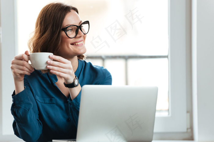 幸福微笑的女人捧着一杯咖啡