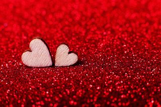 明亮的红色背景上的木制心形图案，作为节日装饰