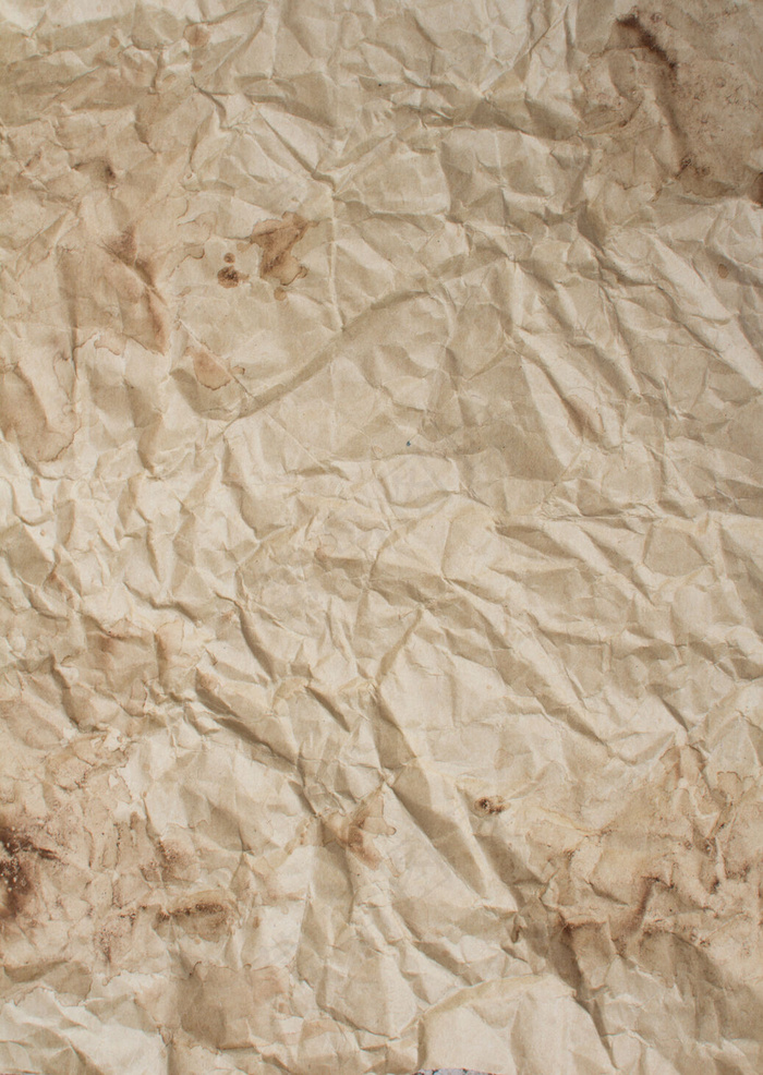 咖啡饮料滴在皱巴巴的牛皮纸背景上