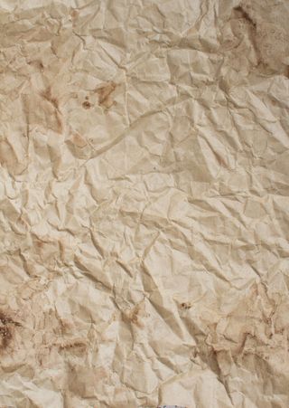 咖啡饮料滴在皱巴巴的牛皮纸背景上