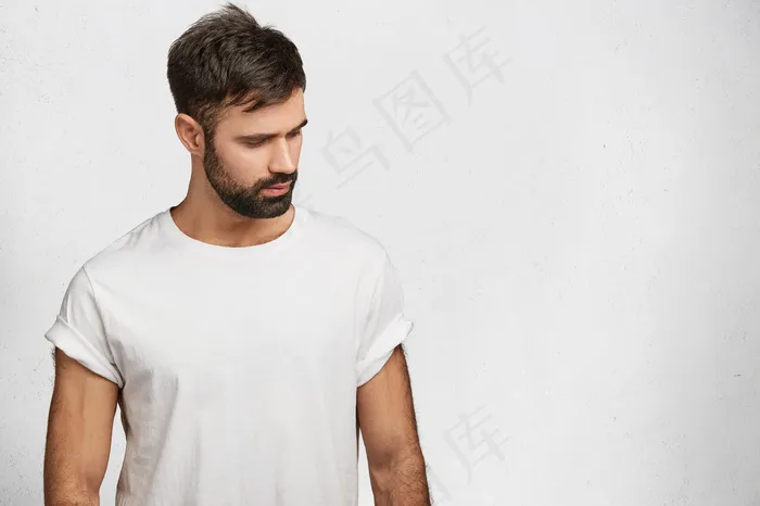 一个留着胡子的年轻人，穿着白t恤