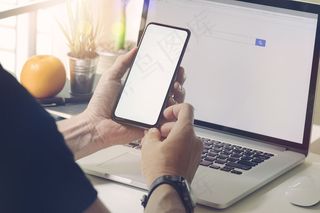 男人坐着用移动智能手机。