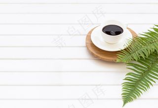 绿色桉树、蕨类植物和一杯黑咖啡的树枝，背景是一块白板，中间有一个空白的文本