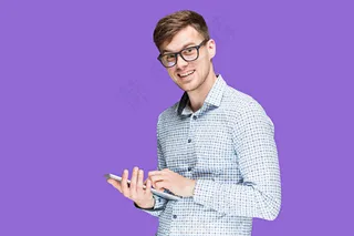 穿着衬衫的年轻人在用紫色的笔记本电脑工作