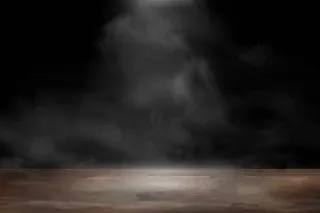 空木桌上冒着烟，在黑暗的背景下飘浮。旧木桌，带聚光灯，烟雾在工作室内，供您使用。