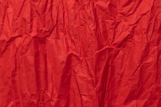 红色皱折的纸纹理，肮脏的背景