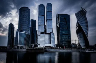 阴暗多云的天空下，河前灰色摩天大楼的低角度拍摄