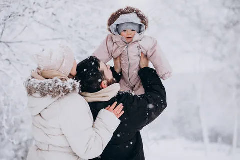 一个年轻的家庭带着小女儿在一片冰雪覆盖的冬季森林里 一个年轻的家庭带着小女儿在一片冰雪覆盖的冬季森林里