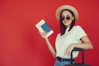 红墙上摆着旅游设备的时髦女孩