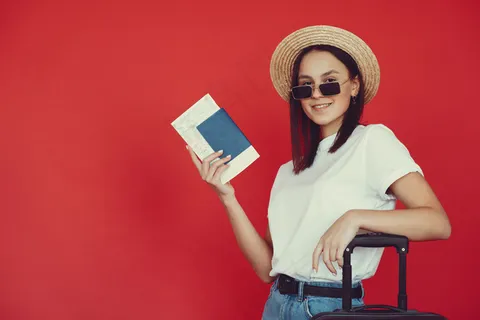 红墙上摆着旅游设备的时髦女孩 红墙上摆着旅游设备的时髦女孩