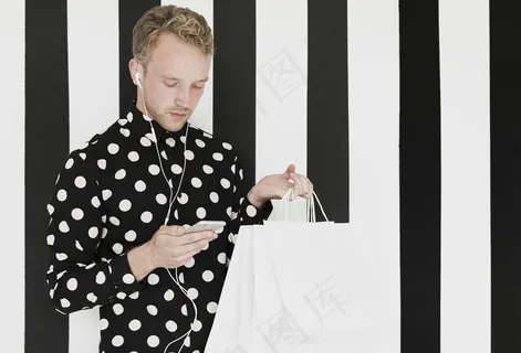 穿着衬衫的金发男人看着智能手机