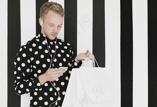 穿着衬衫的金发男人看着智能手机