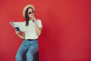 红墙上摆着旅游设备的时髦女孩