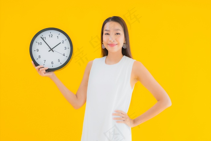 带闹钟或闹钟的美丽亚洲年轻女子肖像