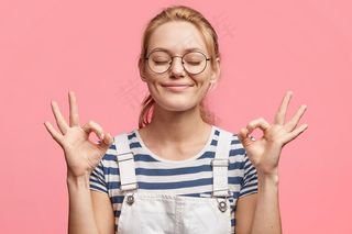 满意的金发美女迷人的快乐女性的肖像表示ok标志，闭上眼睛，心情愉快，周末快乐，与粉色隔离