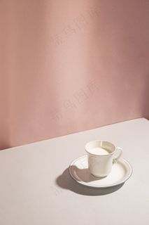 粉红色背景下杯中牛奶的高角度视图