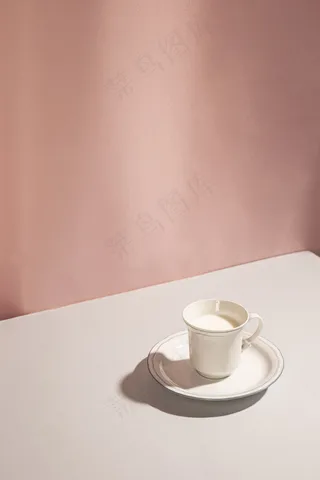 粉红色背景下杯中牛奶的高角度视图