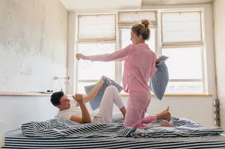 一对年轻夫妇在床上玩得很开心