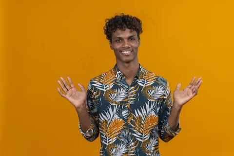 身着衬衫、面带微笑的年轻帅哥张开双臂仰望橙色背景