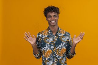 身着衬衫、面带微笑的年轻帅哥张开双臂仰望橙色背景