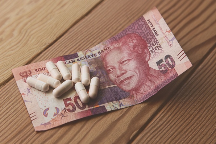 一些胶囊放在南非50兰特的木桌上