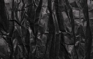 黑色皱折的纸纹理，肮脏的背景