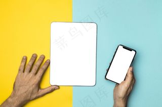 双手紧握手机和平板电脑