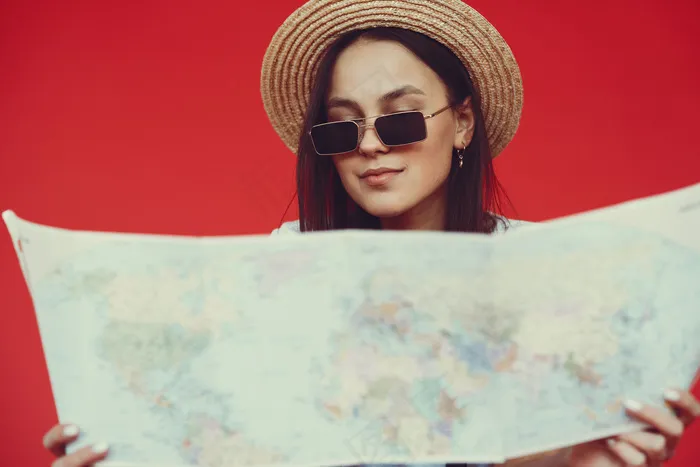 红墙上摆着旅游设备的时髦女孩