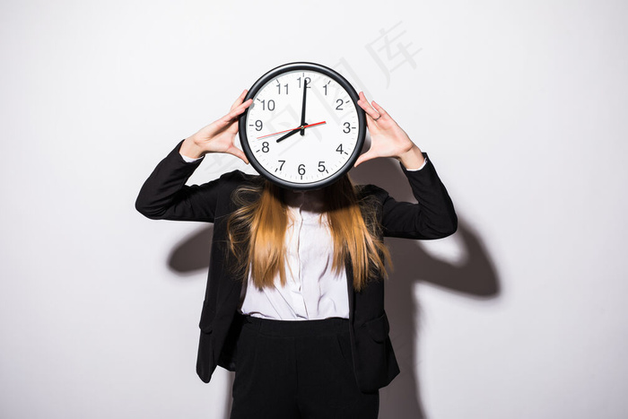 年轻漂亮的女商人手拿着钟，脸上白皙