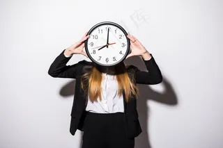 年轻漂亮的女商人手拿着钟，脸上白皙