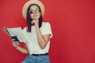 红墙上摆着旅游设备的时髦女孩