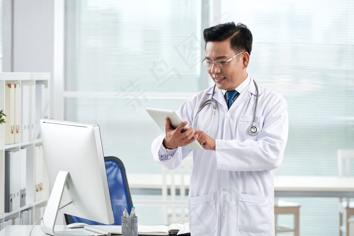 亚洲医生在他的数码设备上使用医疗应用程序