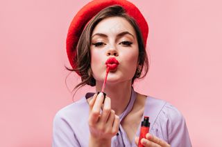 红贝雷帽年轻女孩的肖像画，粉红色的嘴唇上涂着明亮的唇膏。