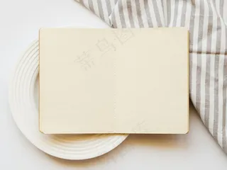 白底白板上浅棕色素描本，灰白色条纹桌布