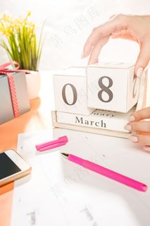 橙色书桌，配有一杯电话、礼物、鲜花和笔记本