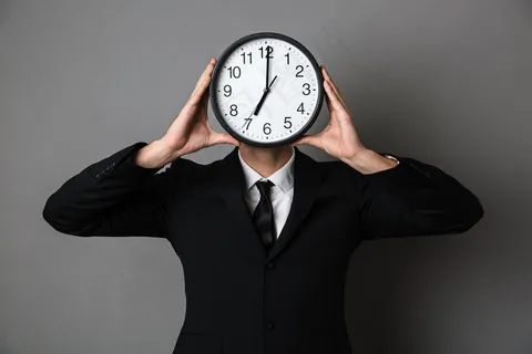 一个穿黑西装的年轻人把钟举在面前 一个穿黑西装的年轻人把钟举在面前