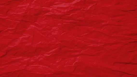 红色皱巴巴的旧纸页纹理粗糙的背景。折痕皱褶羊皮纸图案复古设计。