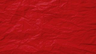 红色皱巴巴的旧纸页纹理粗糙的背景。折痕皱褶羊皮纸图案复古设计。